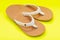 Women`s Causal Braided natural color Beach Day Flip Flops isolated on bright yellow