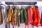 Women`s clothing on rail in the store. Skirts of different colors and textures. Close-up