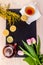 Women& x27;s day greeting card with tulips, mimosa, tea and cupcakes on black stone board background