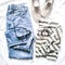 Women`s fashion cassual clothing - jeans, suede shoes and striped t-shirt on a light background, top view