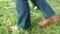 Women`s feet on the grass in shoes and sneakers
