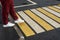 Women`s feet on a pedestrian crossing after the rain