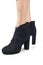 Women`s feet shod in black demi season high heeled ankle boots