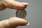 Women`s fingers hold a 10-cent coin,salary drop, minimum payments to authors