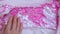 Women's fingers touch the sequins. The pleasure of touch. Pink sequins. Background and texture