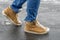 Women`s foots in jeans and demi-season suede boots on asphalt with snow and reagents