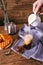 Women`s hand with creamer pouring milk in glass with coffee. Cinnamon sticks, homemade cookies and bunch of wildflowers