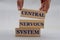 Women`s hand folds wooden bars with words CENTRAL NERVOUS SYSTEM