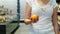 Women\'s hand throws up colourful orange in supermarket in slow-motion