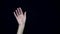 Women`s hand waving. Close-up of female hand flirtatiously waving goodbye. Black isolated background