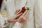 Women`s hands on the background of a white jacket and boutonniere