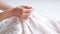 Women\\\'s hands BEAUTIFUL close-up, knitting for a newborn, crochet. top view on soft creamy white background.AI generated