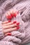 Women\\\'s hands with a beautiful matte oval manicure in a warm pink knitted sweater