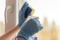 Women`s hands in blue rubber gloves wash Windows, seasonal cleaning