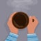 Women`s hands in a blue sweater are warming, gently holding a cup of hot black coffee, with foam. View from above.