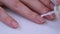 Women's hands close up. The girl covers her nails with a transparent medical varnish. Natural manicure. Nail care