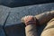 Women`s hands in colored striped winter gloves against a granite stone embankment