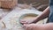 Women's hands with dough. A person prepares homemade pastries from shortcrust pastry, in her hands is a mold and