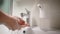 Women`s hands in the frame. The girl used an automatic dispenser for soap. The foam generator has put the right volume.