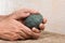 A women\'s hands guiding a child hands to help him to work with raw clay