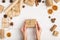 Women`s hands hold a gift of craft paper. Against the background of dried orange, cinnamon, pine cones, anise on a white table.