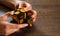 Women`s hands hold mirror magic cube on wooden background