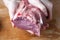 Women`s hands hold a piece of raw beef meat on a wooden background