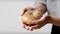 A women\\\'s hands holding a bagel on white background. Generative AI