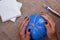 Women`s hands holding a balloon wrapped in jute rope, the process of creating a pumpkin from papier-mache,