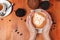 Women`s hands holding a Cup of coffee with a painted Teddy bear latte art. Vintage color. Coffee shop concept