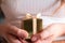Women`s hands holding gold gift box, Holiday present,birthday,Christmas, Father or Mother`s, Valentine`s day close-up