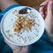 Women`s hands holding a plate of muesli. The view from the top. Close up.