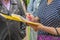 Women`s hands are holding a yellow folder with papers and a notebook in which she makes notes. A group of people.