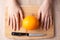 Women`s hands, kitchen knife and lemon on the wooden cutting board