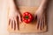 Women`s hands, knife and a Bell pepper on the wooden cutting board