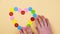 Women`s hands lay out colorful buttons in the shape of a heart. Female hand making heart out of buttons, close-up. Valen