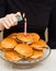 women's hands light a candle on a hamburger cake. original cake.