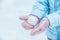 Women`s hands in pink mittens make a snowball for outdoor play in the winter in the forest, Toned and matte