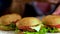 Women\'s hands are placed on table group hamburgers. 4k.