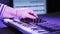 Women`s hands play on a MIDI keyboard and adjust the tone and sound.