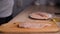 Women\\\'s hands season the fresh chicken breast with salt and pepper on wooden board at home.