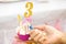 Women`s hands set three candles on fire on Birthday cupcake in pink cup and number 3 on top