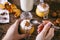 Women`s hands with spoon. Pumpkin milkshake in glass jar with whipped cream, toffee, walnut and honey cookies. Bottle of