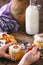 Women`s hands with spoon. Pumpkin milkshake in glass jar with whipped cream, toffee, walnut and honey cookies. Bottle of
