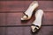 Women`s ivory pump shoe adorned with brush heart on the wooden floor with space, closeup