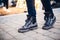 Women`s legs in dark shoes and jeans on street in evening