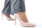 Women& x27;s legs in elegant patent leather high-heeled beige shoes. Gray wide leg jeans. Side view