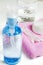 Women`s makeup remover accessories. Gel in a transparent bottle, cotton buds, cotton pads, pink towel