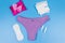 Women`s panties with menstrual cups, sanitary pads and tampons on pastel blue background. Top view