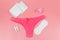 Women`s panties with menstrual cups, sanitary pads and tampons on pastel pink background. Top view